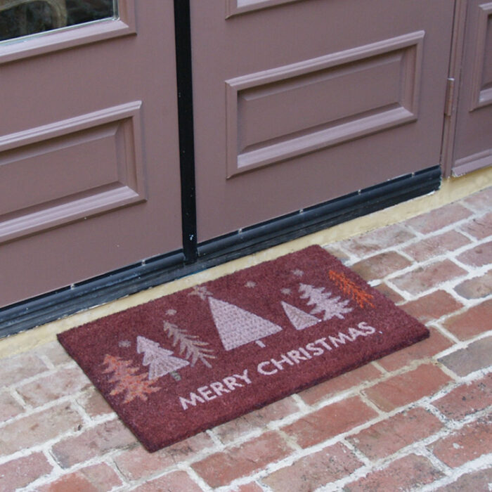 Red Christmas Tree Doormat with white text saying merry christmas in front of a double door mat