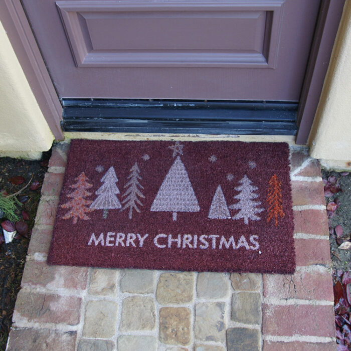 Red Christmas Tree Doormat with white text saying merry christmas in front of a door mat