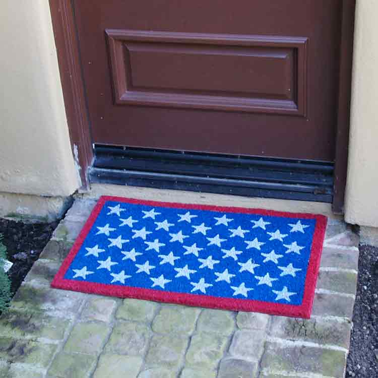 Red, white, and blue Patriotic doormat representing the American flag in front of brown door
