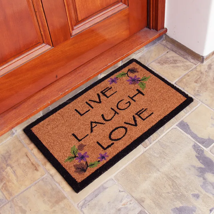 Brown live laugh love mat with black outline in front of brown door