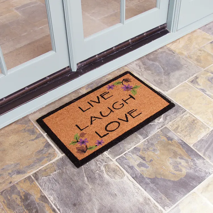 Brown live laugh love mat with black outline in front of white door tilted shot