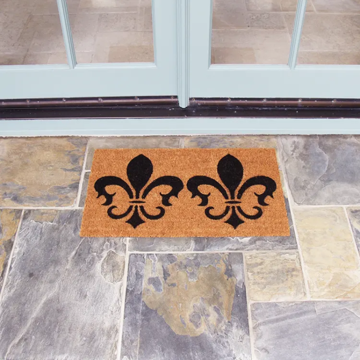 The Clovis Legend Inspired French Mat in Brown and Black in front of double white doors