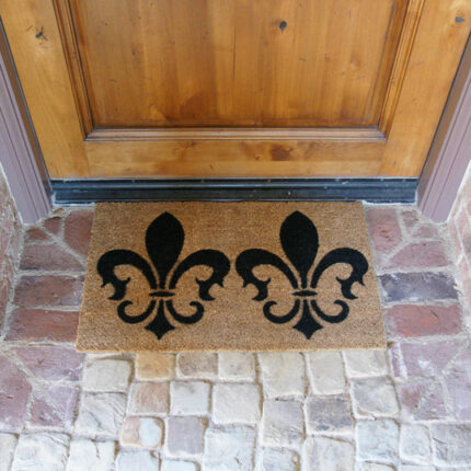 The Clovis Legend Inspired French Mat in Brown and Black in front of a light brown door