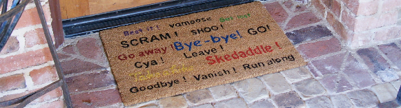 Humorous go away mat in front of door angled shot