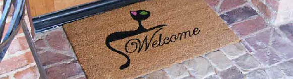 Welcome written in middle with a cat above it brown mat